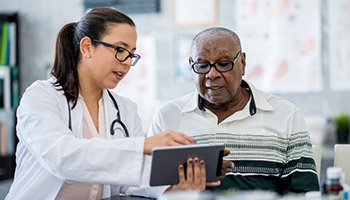 A female doctor looking at a screen with her patient