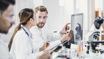 A female scientist and male scientist looking at a computer screen